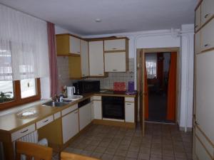 eine Küche mit weißen Schränken und einem Waschbecken in der Unterkunft Ferienwohnung Koch in Bayerisch Eisenstein