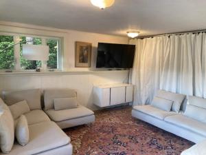 ein Wohnzimmer mit zwei weißen Sofas und einem Flachbildfernseher in der Unterkunft Hot Tub & Pizza Oven Spacious family farm house in Dolphin