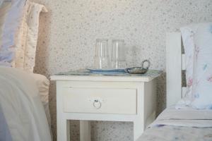 ein weißer Nachttisch neben einem Bett in einem Schlafzimmer in der Unterkunft Casa da Imperatriz in Ilhabela