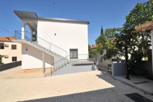 a white building with a staircase on the side of it at Apartments with parking space Seline, Paklenica - 22077 in Starigrad-Paklenica