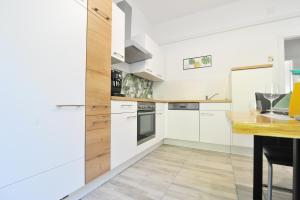 a kitchen with white cabinets and a wooden counter top at Apartments with parking space Seline, Paklenica - 22077 in Starigrad-Paklenica