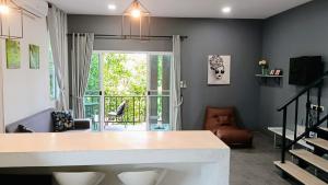 d'un salon avec une table et un balcon. dans l'établissement Villa Rajapruek Private Villa 3 houses combine near Airport, à Chiang Mai
