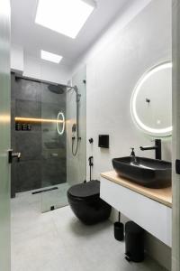 baño con aseo negro y ducha de cristal en Cosy Studio in Central Kathmandu with Terrace, en Katmandú