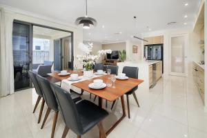 a dining room and kitchen with a table and chairs at The Grand Six at Rochedale in Rochedale
