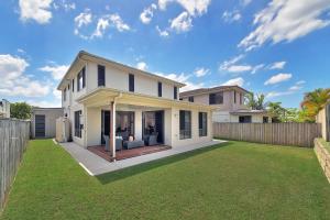 a white house with a yard with a fence at The Grand Six at Rochedale in Rochedale