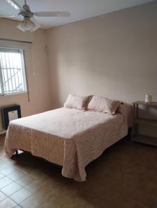 ein Schlafzimmer mit einem Bett in einem Zimmer mit einem Fenster in der Unterkunft CASA MENDOZA CENTRO con Pileta in Mendoza
