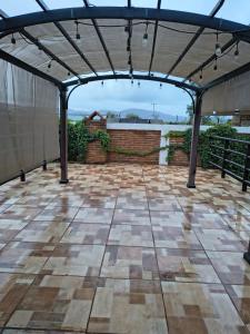 a covered patio with a roof with lights on it at Hotel Flamora in Francisco Zarco