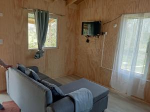 a living room with a couch and a tv and a window at Princesa in Puerto Montt