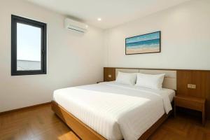 una camera da letto con un grande letto bianco con una finestra di Luxury 88 Hotel a Phủ Lý Altre 14 foto