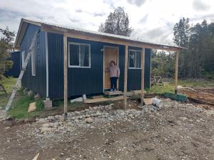 a man standing outside of a tiny house at Princesa in Puerto Montt