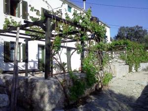 a wooden pergola in front of a house at Gemütliches Ferienhaus Viskic in Supetarska Draga
