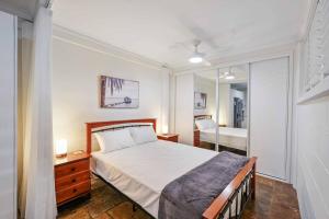 a bedroom with a bed and a mirror at Edge Hill Apartment under Queenslander w Pool in Edge Hill +15 photos