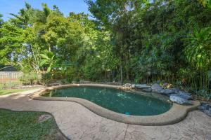 a small swimming pool with a path around it at Edge Hill Apartment under Queenslander w Pool in Edge Hill
