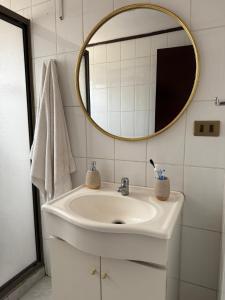 ein Badezimmer mit Waschbecken und Spiegel in der Unterkunft Casa el ensueño Lican Ray, a pasos de playa grande in Licán Ray + 15 Fotos