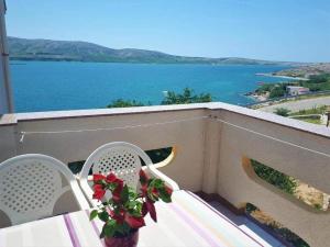 ein Tisch und Stühle auf einem Balkon mit Blick auf das Wasser in der Unterkunft Studio für 2 Personen ca 25 qm in Zubovići, Dalmatien Inseln vor Zadar in Zubovići