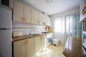 kuchnia z białymi szafkami i zlewem w obiekcie Holiday home MonteMar w mieście Campoamor