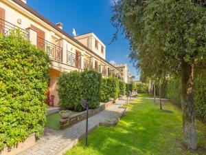 une cour d'un bâtiment avec des arbres et de la pelouse dans l'établissement Apartment in Roma by Marco Simone Golf, à Marco Simone