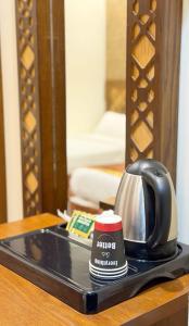 a tea kettle and a cup on a tray on a table at رتاج إن in Al Khansāk +21 photos