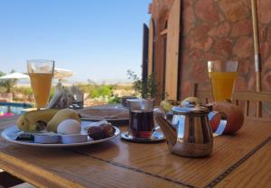 a table with a plate of food and two glasses of beer at Siwa Salt Lake Lodge in Siwa