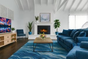 a living room with a blue couch and a fireplace at Peaceful Homestead Getaway - BBQ, Backyard & Farm Life in Toronto