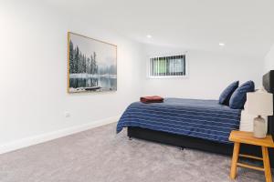 a bedroom with a bed and a picture on the wall at Peaceful Homestead Getaway - BBQ, Backyard & Farm Life in Toronto