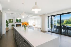 a kitchen with a large white island with flowers in a vase at Peaceful Homestead Getaway - BBQ, Backyard & Farm Life in Toronto +17 photos