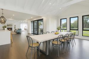 a kitchen and dining room with a white table and chairs at Peaceful Homestead Getaway - BBQ, Backyard & Farm Life in Toronto