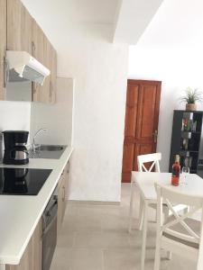 a kitchen with a sink and a table with a white counter at Ferienwohnung Luna in Charco del Palo +12 photos