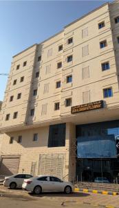 two cars parked in front of a building at رتاج إن in Al Khansāk