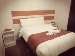 a hotel room with a large bed with white sheets at Belys inn in Cusco