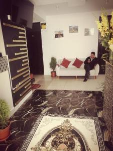 a man sitting on a couch in a living room at Belys inn in Cusco