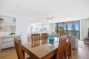 a dining room and kitchen with a table and chairs at Stay in Seaview Resort, 2 BD apartment with ocean views in Mooloolaba