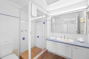 a white bathroom with a sink and a shower at Stay in Seaview Resort, 2 BD apartment with ocean views in Mooloolaba +7 photos