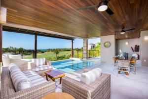 un salon avec des meubles blancs et une piscine dans l'établissement 3bed Condo- Private Pool Golf Cart Ocean View HK, à Tapachula