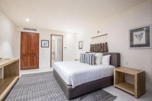 une chambre avec un grand lit et une porte en bois dans l'établissement 3bed Condo- Private Pool Golf Cart Ocean View HK, à Tapachula