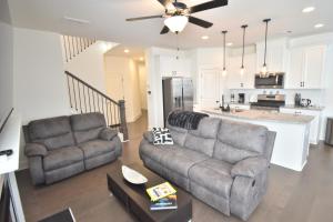 un salon avec deux canapés et une cuisine dans l'établissement Bright, charming, modern townhouse in Winder, à Winder