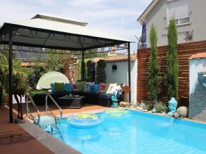 a backyard with a pool with a couch and a pavilion at Ferienwohnung Black For(r)rest Gumpp in Adelhausen