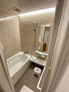 ein Badezimmer mit Badewanne, Waschbecken und Dusche in der Unterkunft Snow Horizon in Hakuba + 32 Fotos