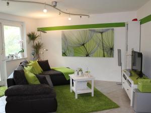 ein Wohnzimmer mit einem Sofa und einem TV in der Unterkunft Ferienwohnung Black For(r)rest Gumpp in Adelhausen