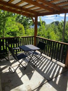 a picnic table and chairs on a deck with a pergola at Las palmeras de Colbún in Colbún