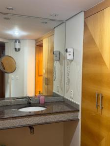 un baño con lavabo y espejo en Flat no Hotel Sol Alphaville, en Barueri