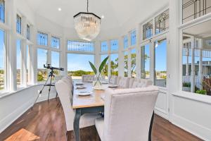ein Esszimmer mit Tisch und Stühlen und Fenstern in der Unterkunft Merewether House 1910 - Iconic and Luxury Home in Merewether