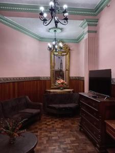 sala de estar con lámpara de araña y espejo en Hostal Tambo de Oro, en La Paz