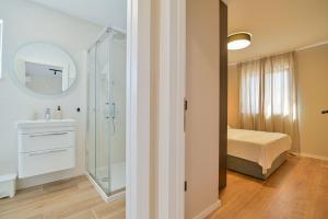 ein Badezimmer mit einem Bett, einem Waschbecken und einem Spiegel in der Unterkunft Ferienwohnung für 4 Personen ca 64 m in Trogir, Dalmatien Kaštela und Umgebung in Trogir + 32 Fotos