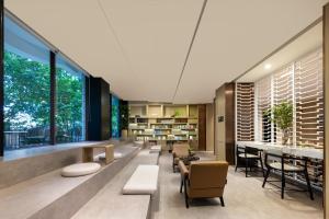 un salon avec des chaises, des tables et des fenêtres dans l'établissement Atour Hotel Financial Street Beijing, à Pékin