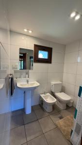 un bagno con lavandino, WC e specchio di Pico Andino a San Carlos de Bariloche