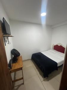 Schlafzimmer mit einem Bett, einem Telefon und einem Tisch in der Unterkunft Hostel Bauti ezeiza in Ezeiza