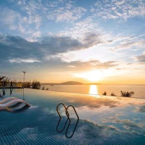 a swimming pool with a view of the ocean at Condotel Highfloor Sea View - Apec Mandala Mui Ne in Mui Ne