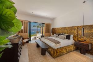 a bedroom with a king sized bed and a desk at 4 Bed - Luxury Oceanview Villa in Punta Mita