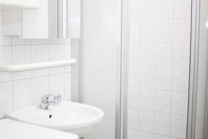 y baño blanco con lavabo y ducha. en Apartment Wichtelgasse, en Viena